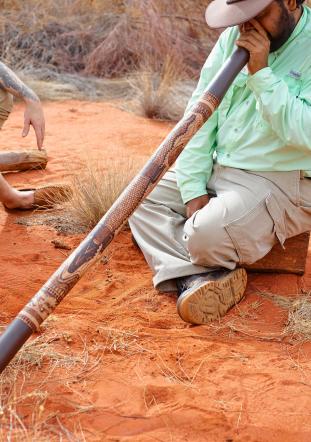 Didgeridoo being played by man in the outback